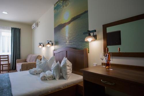 a hotel room with a bed with towels on it at Viktor Bor- és Vendégház**** in Balatonmáriafürdő