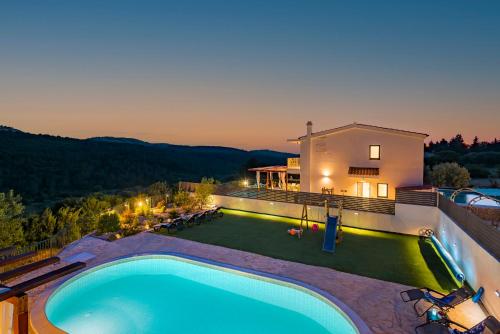 a swimming pool on the side of a house at Villa Plenča green sea near to the sea - heated pool in Šibenik