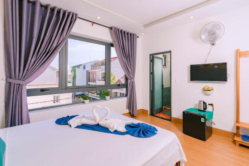 1 dormitorio con cama y ventana grande en Vinh Khang Homestay en Hoi An