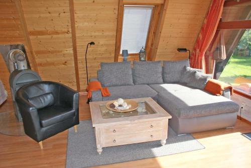 a living room with a gray couch and a chair at Urlaub fuer die ganze Familie im Z in Damp