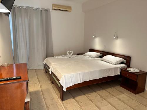 Schlafzimmer mit einem Bett, einer Kommode und einem Schreibtisch in der Unterkunft Aggelos Family Hotel in Moraḯtika