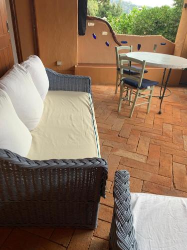 Habitación con sofá, mesa y sillas. en L'Olivastro en Porto Cervo