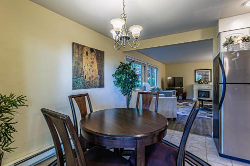 a kitchen and dining room with a table and a refrigerator at the Lanai, Best Area, 2 Bedrooms, WD, Large Balcony, Condo, 825sf in Tacoma