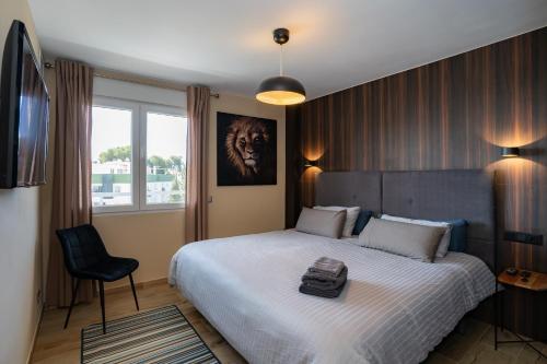 een slaapkamer met een groot bed en een stoel bij Los Riscos Luxury Apartment - Torremolinos in Torremolinos