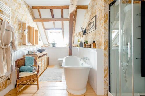 uma casa de banho com uma banheira e um lavatório em Au Charme D'ici em La Chapelle-Saint-Sauveur