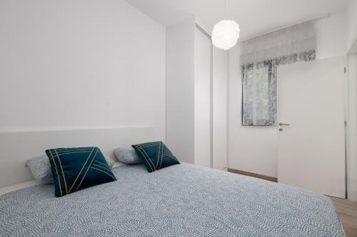 um quarto com uma cama com duas almofadas em Apartment KriLa em Kaštela