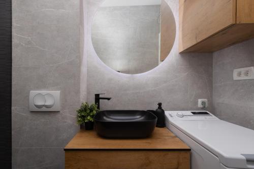 ein Badezimmer mit einem schwarzen Waschbecken und einem Spiegel in der Unterkunft Apartment KriLa in Kaštela