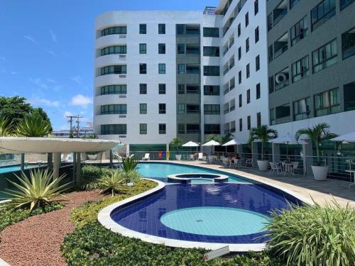 a large swimming pool in front of a building at Loft Luxor Tambaú in João Pessoa