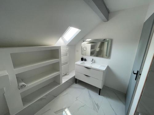uma casa de banho branca com um lavatório e um espelho em Appartement Familiale PREMIUM : proche gare de Belfort em Belfort
