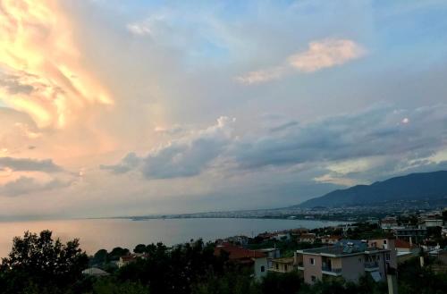 a view of a city and a lake at sunset at SEMIRAMIS SUITES with pool in Kalamata