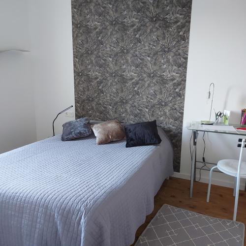 a bedroom with a bed with two pillows on it at Charmant appartement proche Carcassonne in Escueillens