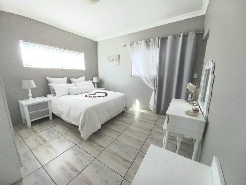 a small bedroom with a white bed and a window at Bel-Posto, Langebaan in Langebaan