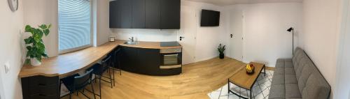 uma sala de estar com uma cozinha com piso em madeira em Apartman Tatry em Mlynica