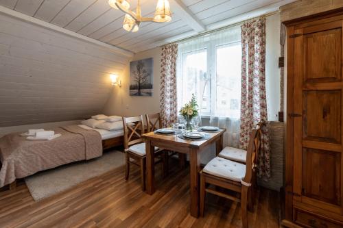 シュチルクにあるDomki i Apartamenty Cicha Dolina Przy Beskid Sport Arenaのベッド1台、テーブル、ベッドルーム1室が備わる小さな客室です。