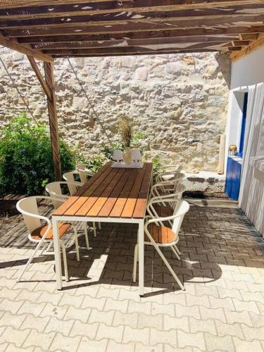 une table et des chaises en bois sur une terrasse dans l'établissement Maison 120m2 / centre ville / grand jardin 250m2, à Sète