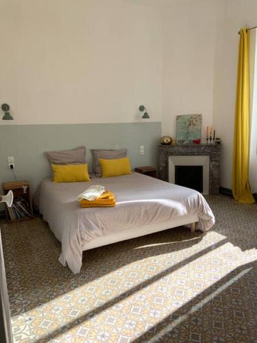 une chambre avec un grand lit avec des oreillers jaunes dans l'établissement Maison 120m2 / centre ville / grand jardin 250m2, à Sète