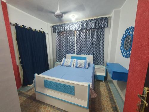 a bedroom with a blue and white bed and a window at Abeer Suites 3 basement in Hurghada