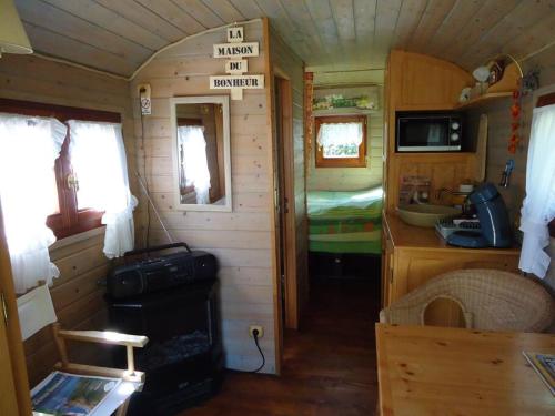 mały pokój z kuchnią i sypialnią w małym domku w obiekcie Roulotte dans un cadre verdoyant w mieście Hermelinghen