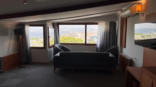a living room with a couch and two windows at Varyant Hotel in Konak
