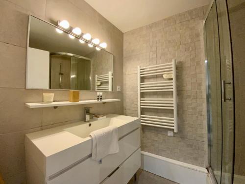 W łazience znajduje się umywalka i lustro. w obiekcie GROOMI Le St Roch - 1 chambre et position centrale ! w Montpellier