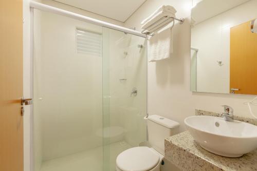 a bathroom with a toilet and a sink and a shower at Tri Hotel São João Batista in São João Batista