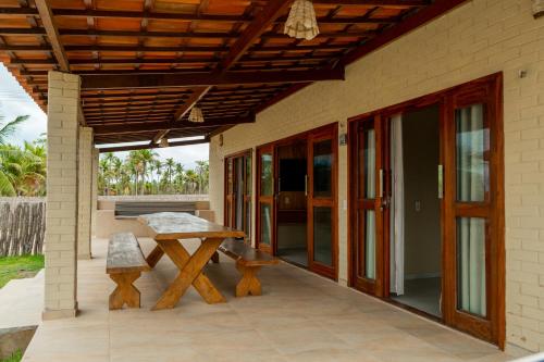 a patio with a table and a bench on a house at Chalé Bistrô Maceió in Camocim
