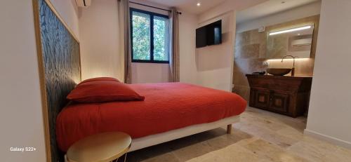 a bedroom with a red bed and a sink at A Pasturella, jacuzzi privé in Venzolasca
