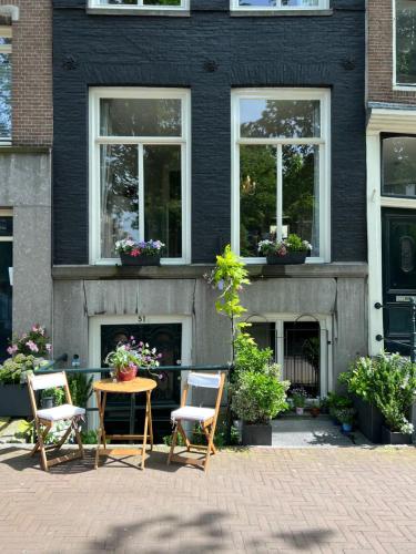 a patio with chairs and a table in front of a house at Singel Residence in Amsterdam