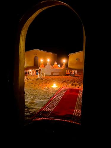 a view of a bed in a desert at night at Desert Erg Chegaga Camp in El Gouera