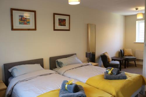 - une chambre avec 2 lits et des serviettes dans l'établissement 4 Bed Luxury Home in Broughton by Goshen Properties, à Milton Keynes