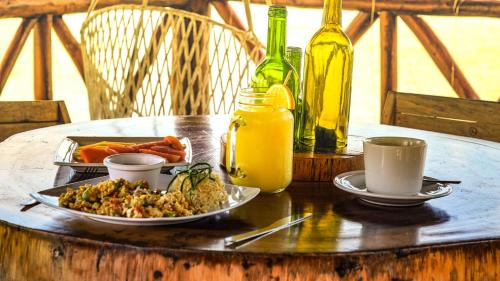 a table with a plate of food and a bottle of wine at Hotel Rio Lagartos in Río Lagartos