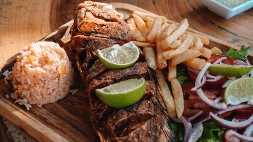 a plate of food with rice and meat and fries at Hotel Rio Lagartos in Río Lagartos