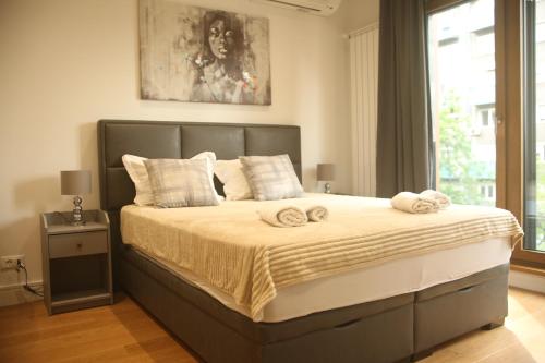 um quarto com uma cama grande e toalhas em Natalie's Condo em Belgrado