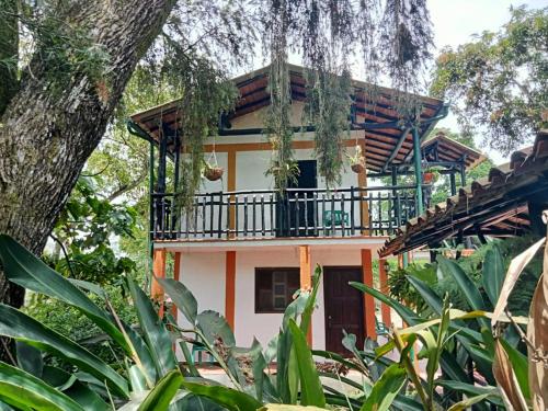 a house with a balcony on top of it at CABAÑA EL PEZ SAN GIL in San Gil