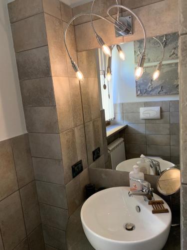 La salle de bains est pourvue d'un lavabo blanc et d'un miroir. dans l'établissement Podere Casallorto, à Volterra