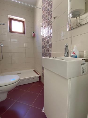 a bathroom with a sink and a toilet and a tub at Maslina in Orebić