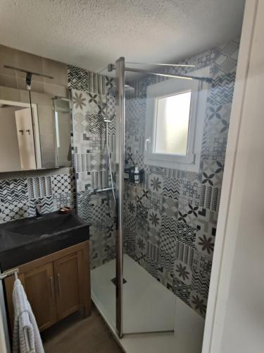 une salle de bain avec une douche et un lavabo et une fenêtre dans l'établissement Petite maison avec jardin à 400m de la plage, à Sarzeau