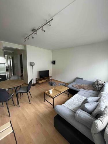 uma sala de estar com um sofá e uma mesa em 4-mannsbolig sentralt i Auli 
