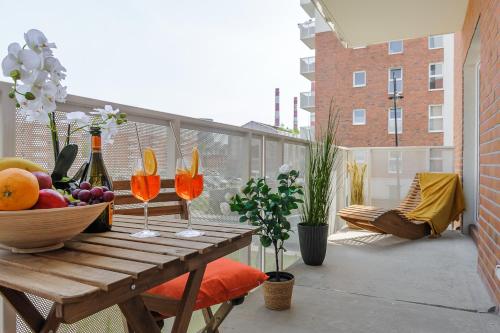 una mesa de madera con copas de vino y fruta en el balcón en Lumina premium apartments with balcony, parking, en Łódź