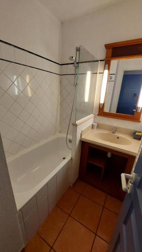 ein Bad mit einer Badewanne, einem Waschbecken und einer Dusche in der Unterkunft AGREABLE T2 LISIERE DU GOLF LACANAU OCEAN in Lacanau-Océan