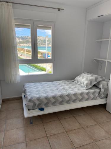 1 dormitorio con 1 cama y 2 ventanas en Inmejorables vistas al mar Javea en Jávea