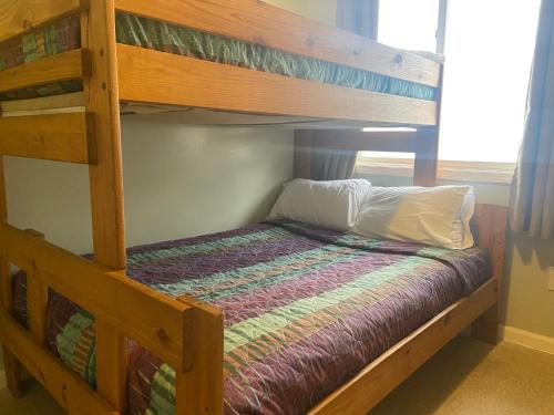 a bedroom with a bunk bed with a wooden bunk bedutenewayangering at Gold Coast Family Cottages in Oscoda