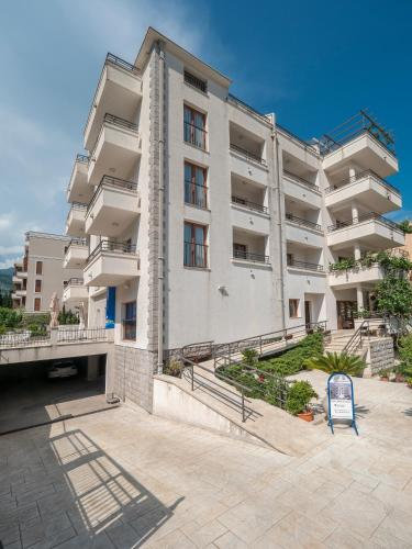 an apartment building with a sign in front of it at Apartments Butua in Budva