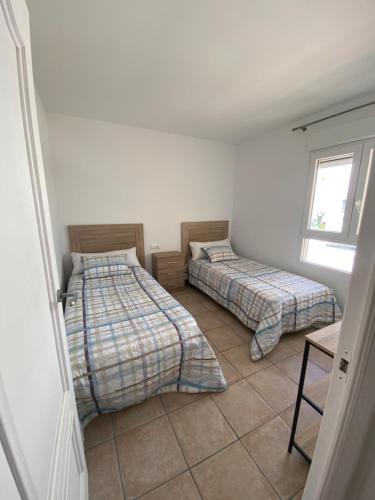 1 dormitorio con 2 camas y ventana en Inmejorables vistas al mar Javea en Jávea