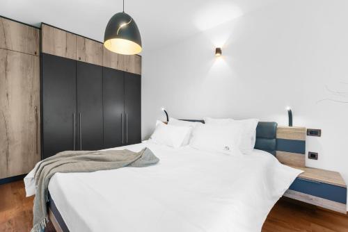 a bedroom with a large white bed with a black headboard at Apartment Mia in Labin