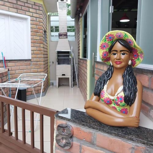 a statue of a woman wearing a hat on a porch at Chalé 08 Porto dos Lençóis in Barreirinhas