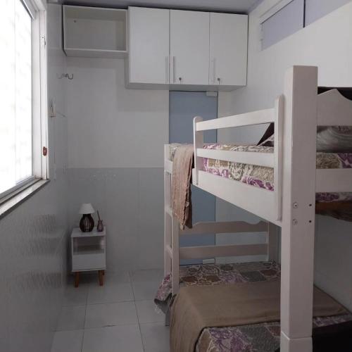 a room with two bunk beds and a window at Chalé 08 Porto dos Lençóis in Barreirinhas