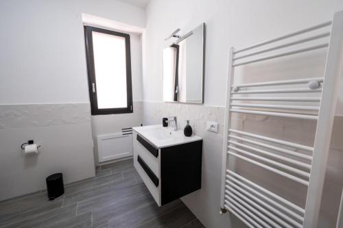 uma casa de banho branca com um lavatório e um espelho em AVA VACATION HOME em Borgetto