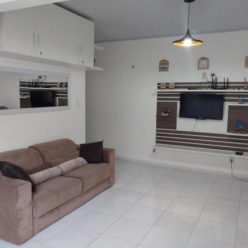 a living room with a couch and a kitchen at Chalé 08 Porto dos Lençóis in Barreirinhas
