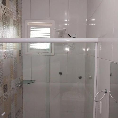 a white bathroom with a shower and a window at Chalé 08 Porto dos Lençóis in Barreirinhas